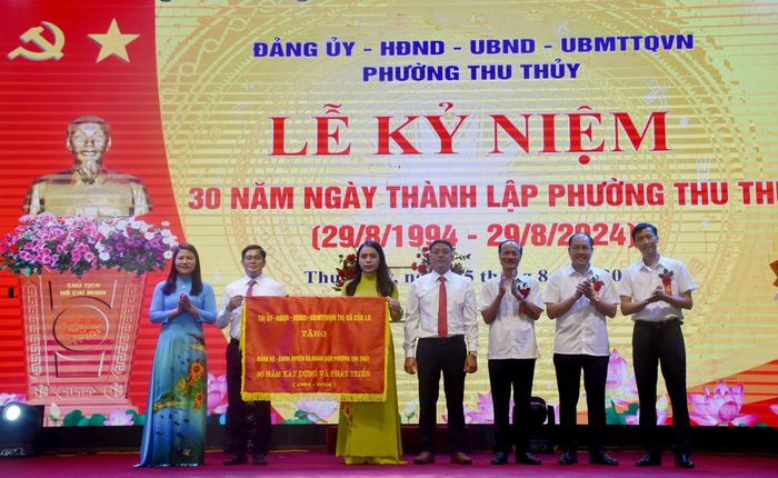 Thị ủy, HĐND, UBND, Ủy ban MTTQ thị xã Cửa Lò trao tặng Bức trướng mang dòng chữ: Đảng bộ, chính quyền và nhân dân phường Thu Thủy phát huy truyền thống 30 năm “Đoàn kết - Đổi mới - Khát vọng - Phát triển”. Ảnh: Thu Hương