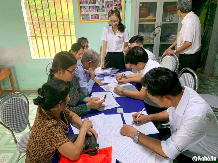 Cán bộ BHXH huyện Tân Kỳ phối hợp chính quyền địa phương và các ngân hàng thương mại hướng dẫn người hưởng lương hưu. Ảnh: Q.A