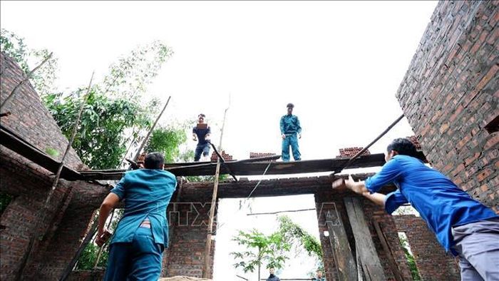 Lực lượng Dân quân tự vệ và Đoàn Thanh niên xã Nà Hẩu (Văn Yên, Yên Bái) giúp đỡ xây dựng nhà cho hộ nghèo. Ảnh: TTXVN phát