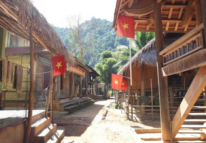 Khung cảnh khu bản làng Xốp Kho (xã Nga My, huyện Tương Dương, Nghệ An) của đồng bào Thái nằm trong vùng đệm Khu bảo tồn Thiên nhiên Pù Huống rợp bóng cờ Tổ quốc