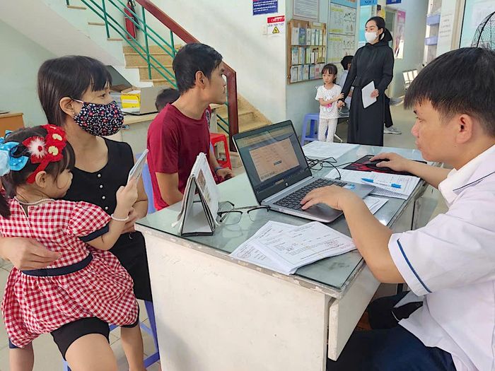  Người dân đưa trẻ đến trạm y tế phường Tây Thạnh tiêm chủng. Ảnh: QUANG HUY 