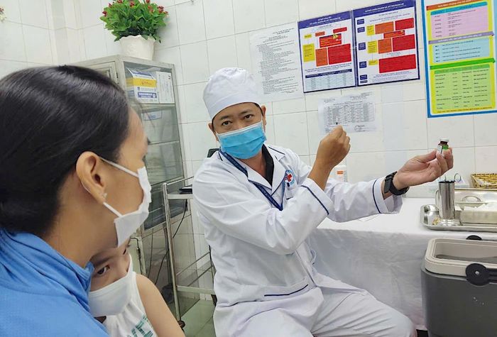  Bác sĩ tư vấn về vaccine sởi cho mẹ trẻ trước khi tiêm Ảnh: QUANG HUY 