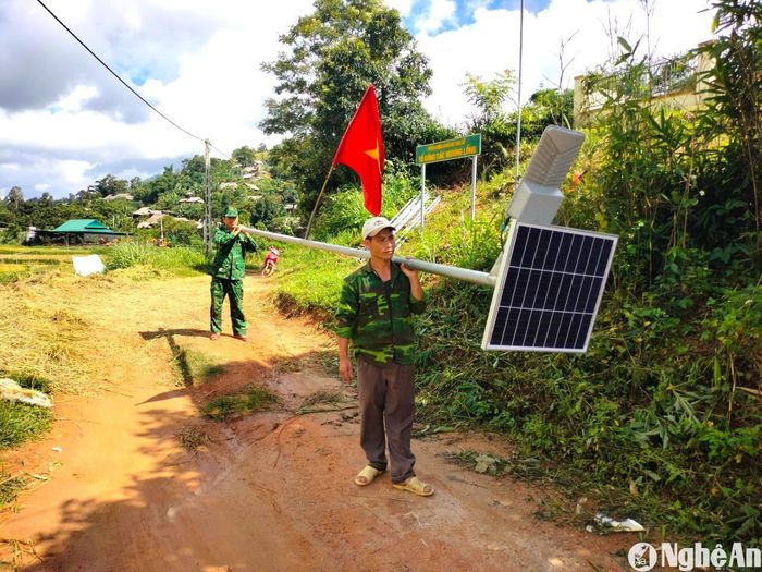 Cán bộ Đồn Biên phòng Tri Lễ và người dân vận chuyển vật liệu lắp đặt hệ thống đèn năng lượng mặt trời ở bản Mường Lống. Ảnh: K.L