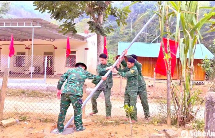 Cán bộ, chiến sĩ Đồn Biên phòng Tam Hợp (Tương Dương) triển khai lắp đặt hệ thống cột đèn năng lượng mặt trời thắp sáng đường vào thôn, bản. Ảnh: G.H