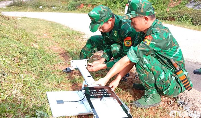 Cán bộ, chiến sĩ Đồn Biên phòng Nậm Càn (Kỳ Sơn) triển khai lắp các bóng đèn năng lượng mặt trời phục vụ đi lại của người dân. Ảnh: G.H