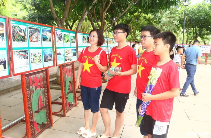 Du khách tham quan Triển lãm ảnh chủ đề "Di chúc Bác Hồ - ngọn đuốc soi đường" tại làng Sen. Anh Nguyễn Quang Thạch (43 tuổi) đến từ huyện Đông Anh, Thủ đô Hà Nội cùng gia đình đang tham quan tại khu trưng bày cho biết: Sáng hôm nay (2/9), đúng ngày Bác mất, cả gia đình tôi đã về thăm quê Bác với bao cảm xúc khó tả, không có gì nói hết được ngoài lòng kính yêu và biết ơn vô hạn đối với Bác Hồ. Ảnh: Huy Thư