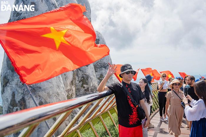 Khu du lịch Sun World Bà Nà Hills được trang trí rực rỡ bằng cờ Tổ Quốc. Trong ảnh: Du khách quốc tế thích thú check-in tại khu vực cầu Vàng. Ảnh: THU HÀ.
