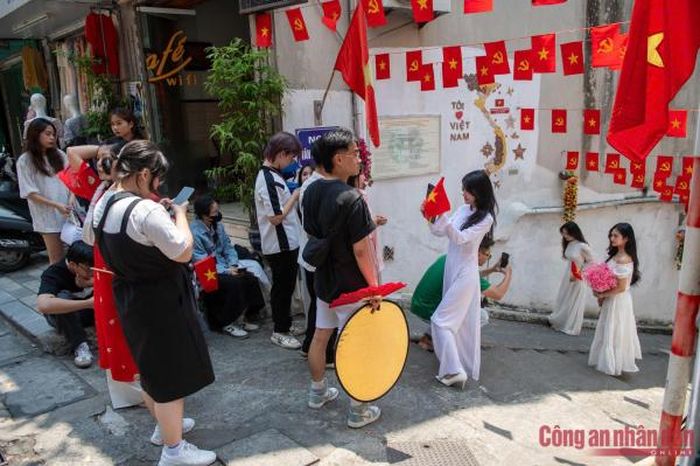 Thời tiết có nắng và đường phố tràn ngập cờ đỏ cũng là một điều kiện lý tưởng để nhiều cô gái chọn để ra đường chụp ảnh lưu lại những kỷ niệm.