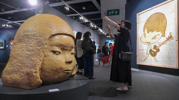Du khách chụp ảnh với tác phẩm của Yoshitomo Nara trong đợt bán hàng mùa Xuân của Sotheby’s Hong Kong vào tháng 4/2024