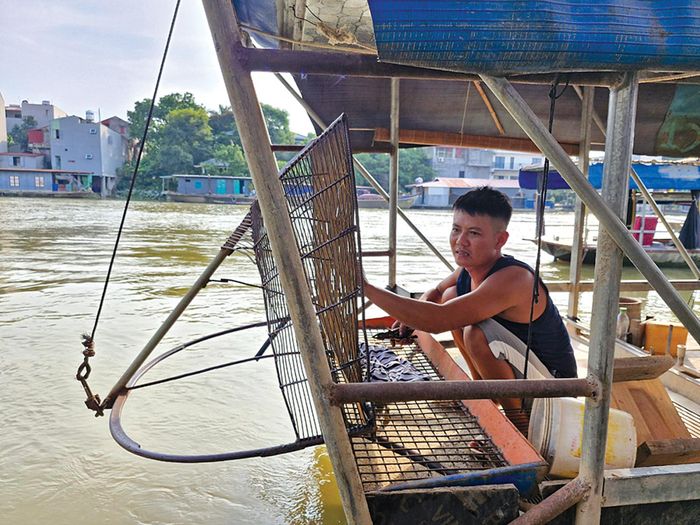 Anh Trần Văn Vững, thôn Nguyệt Đức chuẩn bị dụng cụ cào để tối đến sẽ đi cào hến trên sông Cầu, đây là công việc cho thu nhập chính của gia đình 4 người.