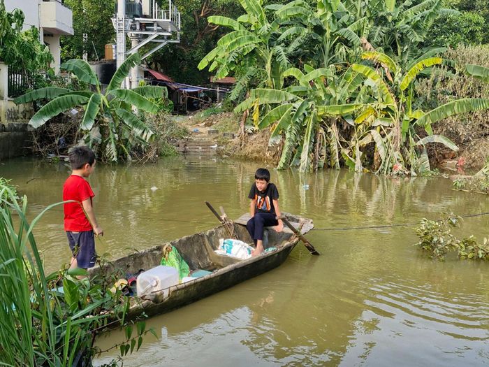 Chèo thuyền, nô đùa trên sông Cầu là thú vui của nhiều đứa trẻ làng Nguyệt Đức.