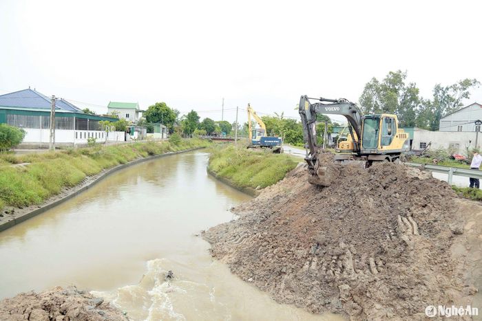 Huy động máy móc khơi thông dòng chảy trên tuyến kênh Lê Xuân Đào đoạn qua xã Hưng Nghĩa, huyện Hưng Nguyên. Ảnh: Phú Hương