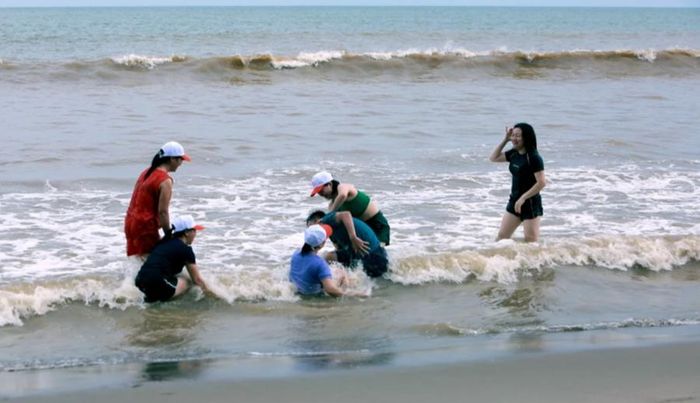 Nhóm du khách vô tư đùa nghịch trên biển dù các phương tiện báo đài truyền thông đưa tin về siêu bão Yagi.