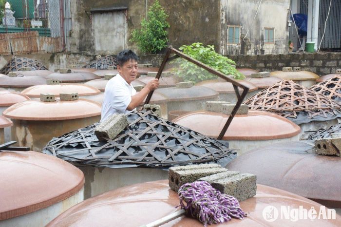 Tại các cơ sở chế biến nước mắm, người dân cẩn thận che đậy các chượp ủ, bởi nếu nước mưa lọt vào thì sẽ hỏng, phải đổ bỏ. Ảnh: CSCC