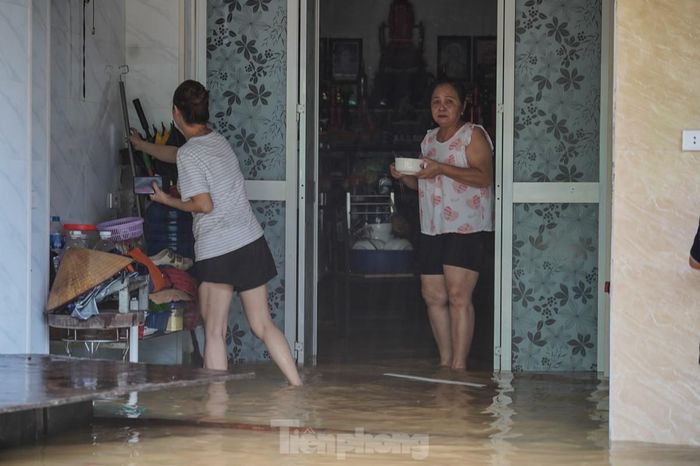  Đường ngập, cùng với cúp điện, người dân dùng bếp ga nấu mì ăn tạm. 