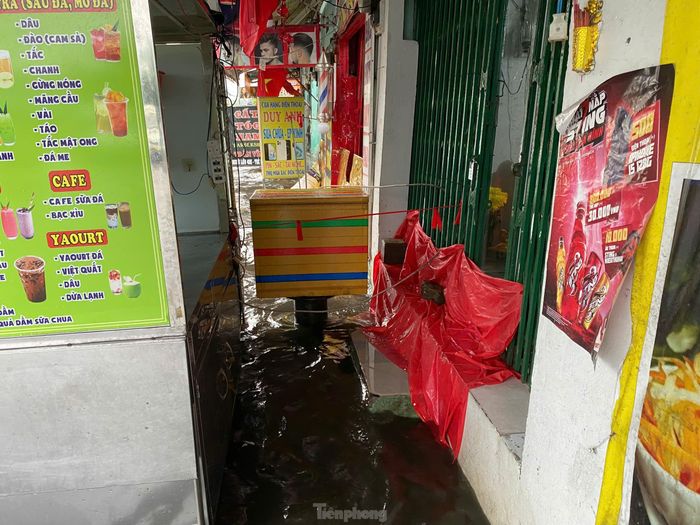 Một số hàng quán trên đường Sinco phải đóng cửa và che chắn để tránh nước văng vào nhà. 