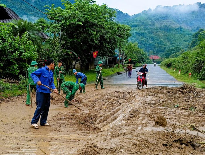 Cán bộ chiến sĩ Đồn Biên phòng Thông Thụ (Quế Phong) cùng các lực lượng, nhân dân địa phương khắc phục các điểm sạt lở do mưa lớn kéo dài đảm bảo giao thông trên đường 48. Ảnh: Lê Thạch
