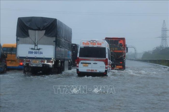 Các phương tiện di chuyển chậm qua đoạn ngập Km 191 + 500 trên cao tốc Pháp Vân - Cầu Giẽ (ảnh chụp lúc 10h30 ngày 11/9). Ảnh: Hoàng Hiếu/TTXVN