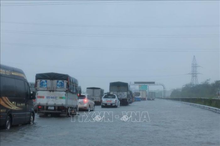 Các phương tiện di chuyển chậm qua đoạn ngập Km 191 + 500 trên cao tốc Pháp Vân - Cầu Giẽ (ảnh chụp lúc 10h30 ngày 11/9). Ảnh: Hoàng Hiếu/TTXVN
