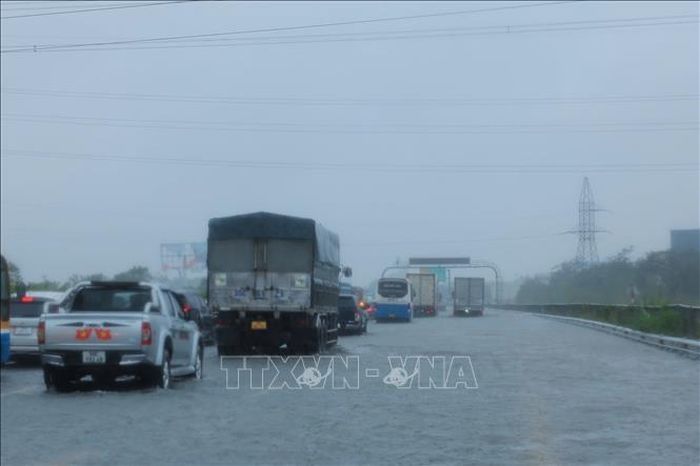 Các phương tiện di chuyển chậm qua đoạn ngập Km 191 + 500 trên cao tốc Pháp Vân - Cầu Giẽ (ảnh chụp lúc 10h30 ngày 11/9). Ảnh: Hoàng Hiếu/TTXVN
