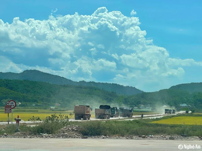 Xe chở đất chạy từng đoàn tung bụi mù mịt trên đường. Ảnh: Tiến Đông
