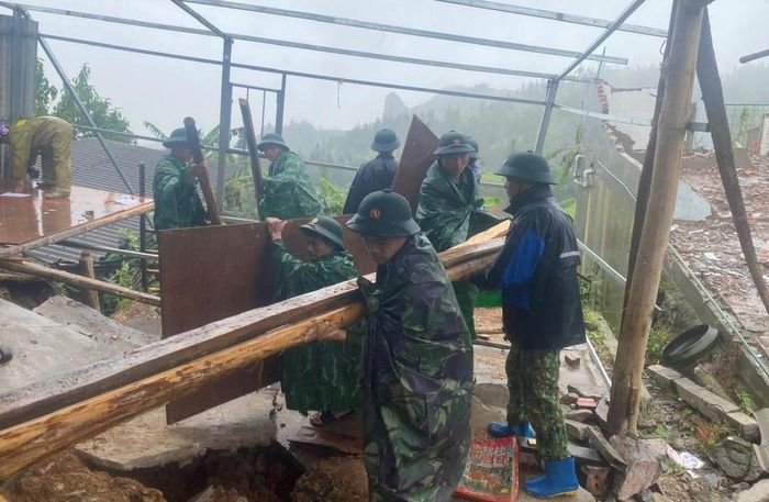 Cán bộ, chiến sĩ BĐBP Hà Giang hỗ trợ người dân di dời tài sản ra khỏi khu vực bị sạt lở đất. Ảnh: Tiến Thắng