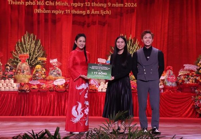 Đại diện ekip chương trình Anh trai "say hi” trao bảng tượng trưng ủng hộ 1 tỷ đồng cho người dân bị ảnh hưởng bởi bão số 3. Ảnh: Thu Hương - TTXVN