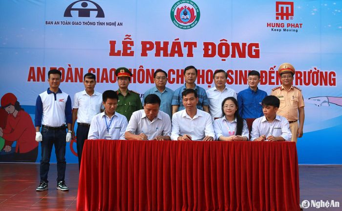 Đại diện nhà trường, Hội phụ huynh, học sinh tham gia ký kết việc chấp hành Luật Giao thông. Ảnh: Đ.C