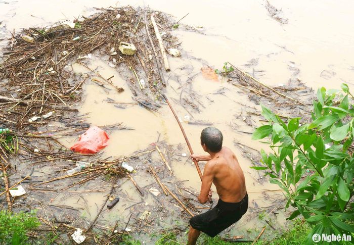 Tham gia công việc vớt củi lụt trên sông ở vực Quánh có không ít người già. Một số người có thâm niên hàng chục năm vớt củi ở đây khi có lũ. Dù trẻ hay già, đứng trên bờ hay ngồi dưới sông, nhưng không có ai sử dụng áo phao. Ảnh: Huy Thư