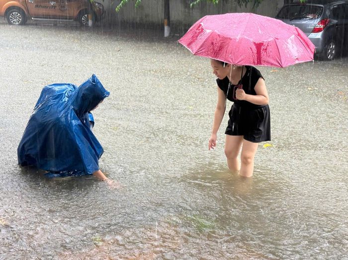Người dân trên đường Đinh Lễ, phường Hưng Dũng khơi vét miệng cống thoát bị rác thải làm tắc nhằm tăng khả năng tiêu thoát nước. Ảnh: Nguyễn Hải