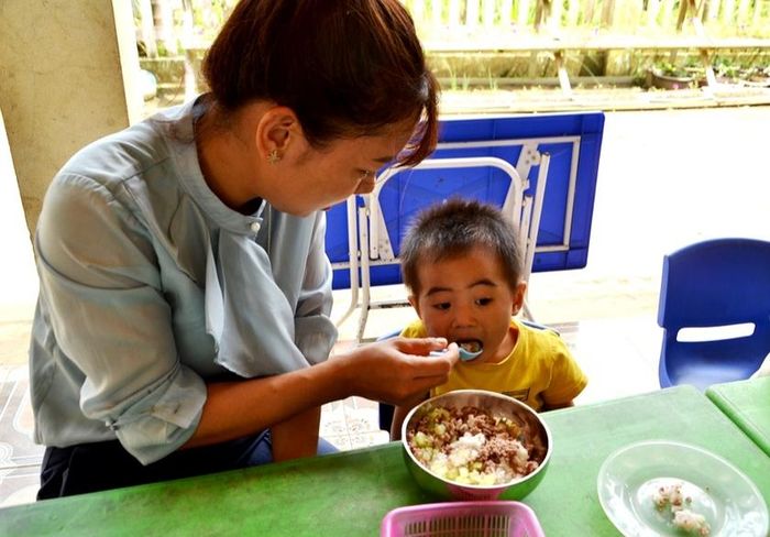 Cô giáo như mẹ hiền - chăm chút các con sau hoạn nạn đau thương ở Làng Nủ. Ảnh: Quốc Hồng