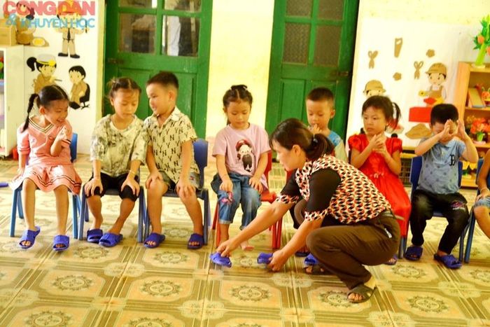 Cô lựa cho các con từng đôi dép vừa chân. Ảnh: Quốc Hồng