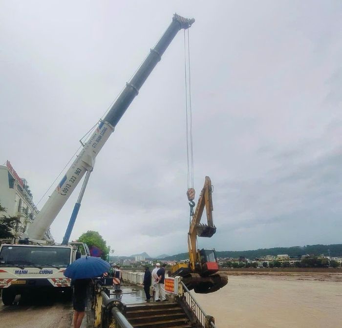 Lực lượng chức năng trục vớt một chiếc máy xúc, đảm bảo an toàn tài sản cho người dân. Ảnh: Báo Lào Cai