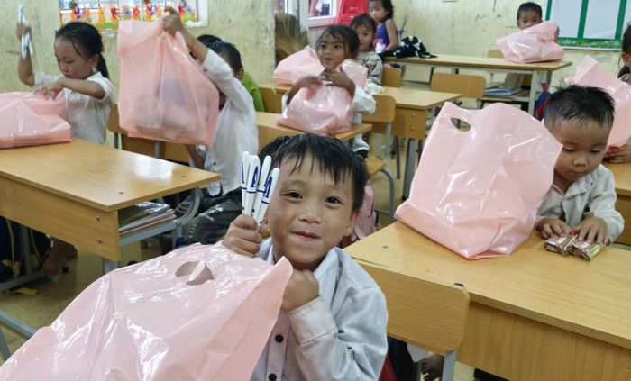 Nhiều em học sinh phấn khởi được nhận món quà ý nghĩa và hứa sẽ học tập thật tốt. Ảnh: PV