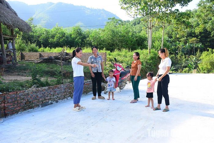 Chị Lý Thị Hương, thôn Cây Quéo, xã Hùng Đức (Hàm Yên) cùng bà con vui mừng đi trên con đường bê tông mới.