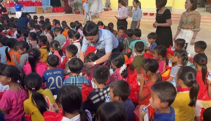 Tổng Biên tập Báo Công lý Trần Đức Vinh quây quần, trò chuyện cùng các cháu học sinh tại Trường Tiểu học Pu Nhi.