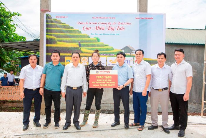 Đồng chí Trần Đức Vinh, Tổng Biên tập Báo Công lý và ông Lương Tiến Phương, Phó Chánh án TAND tỉnh Điện Biên trao tiền hỗ trợ xây nhà cho gia đình chị Quàng Thị Tâm tại xã Chiềng Sinh, huyện Tuần Giáo, tỉnh Điện Biên.