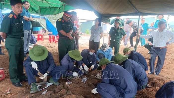 Lực lượng chức năng thực hiện quy trình quy tập hài cốt liệt sĩ. Ảnh: TTXVN phát