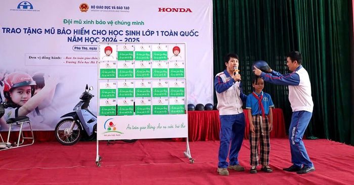 Hướng dẫn viên lái xe an toàn của Công ty TNHH Bình Minh hướng dẫn học sinh cách đội mũ an toàn.