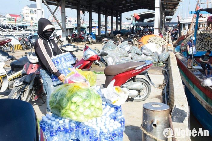 Trước mỗi chuyến ra khơi, người vợ, người mẹ chuẩn bị chu đáo cho các thuyền viên lương thực, thực phẩm. Ảnh: T.P