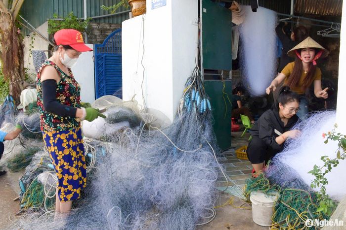 Thuyền ra khơi, ở lại trên bờ, họ lại bắt tay vào vá lưới, chuẩn bị ngư cụ cho những chuyến biển tiếp theo. Ảnh: T.P