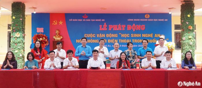 Các đại biểu chứng kiến lễ ký cam kết của các Phòng Giáo dục và Đào tạo, các nhà trường và các trung tâm GDNN - GDTX về việc thực hiện cuộc vận động "Học sinh Nghệ An nói không với điện thoại trong buổi học". Ảnh: Mỹ Hà