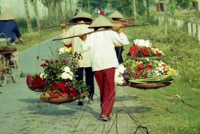 Một khoảnh khắc khá thú vị khi cả ba phụ nữ cùng “đổi vai”, tức là chuyển đòn gánh từ vai nọ sang vai kia. Tôi không đi chợ bán hoa, nhưng có nhiều năm gánh nước tưới hoa mà không biết làm như họ, nên giờ vai bị lệch