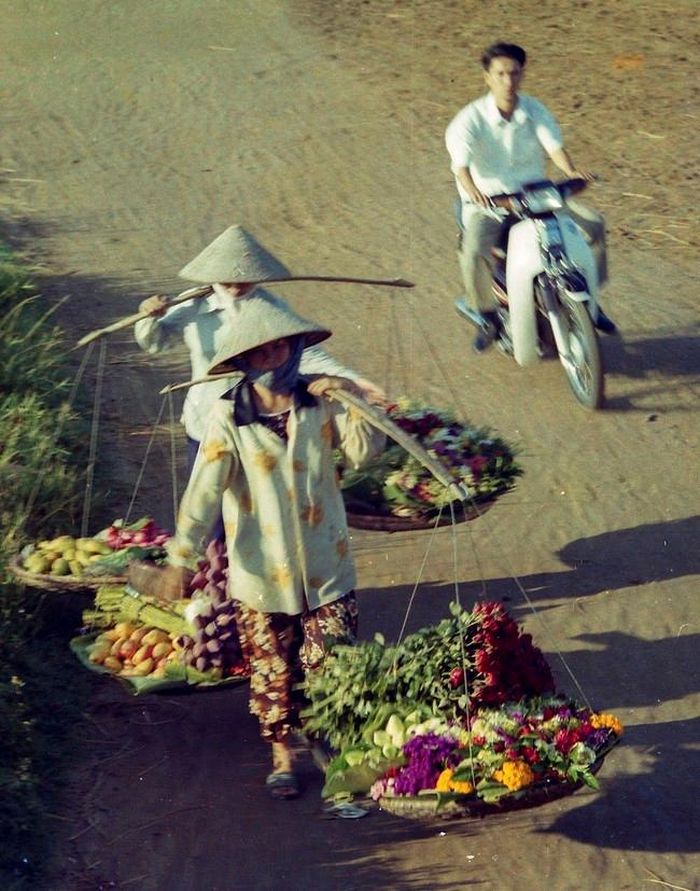 Các gánh hoa đi trên “đường bao phía Nam” TP Hải Phòng những năm đầu 1990s, khi ấy mới chỉ được san gạt, con đường này nay là QL5 kéo dài
