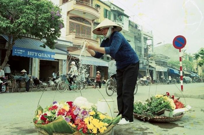 Cô Dung, bạn học cấp 1 của tôi, đang vẩy nước cho hoa trên phố cổ Tam Bạc, năm 2000