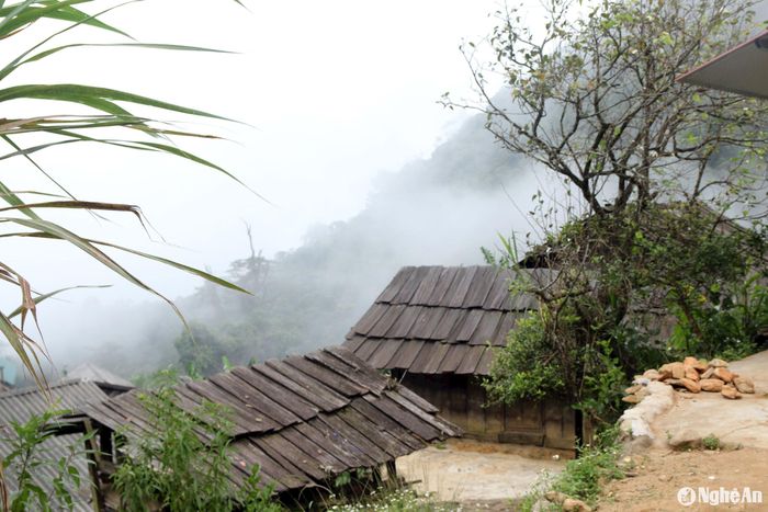 Bên những mái nhà lợp bằng gỗ sa mu truyền thống của người Mông, sương mây bay là tà, tạo thành một làn mưa mỏng khiến không khí nơi đây lạnh hơn so với các địa bàn khác. Ảnh: Đào Thọ