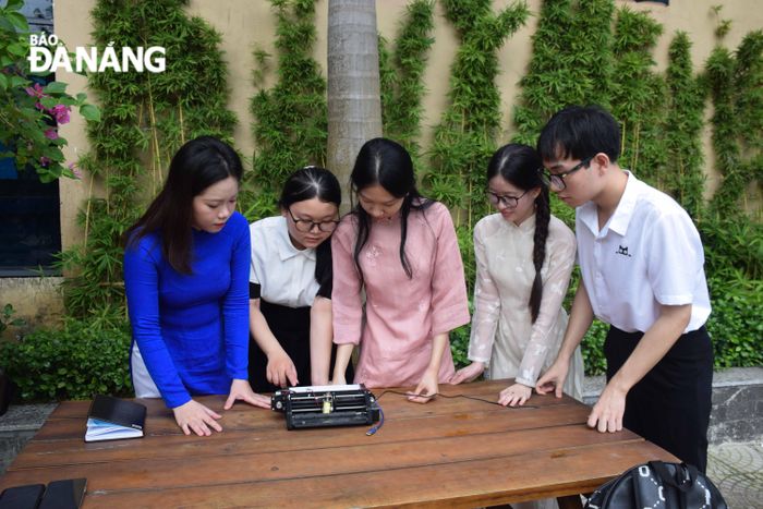 Sinh viên Lê Thanh Trúc cùng nhóm nghiên cứu của mình kiểm tra lại hoạt động của chiếc máy in chữ nổi sau khi chế tạo. Ảnh: Đ.H.L