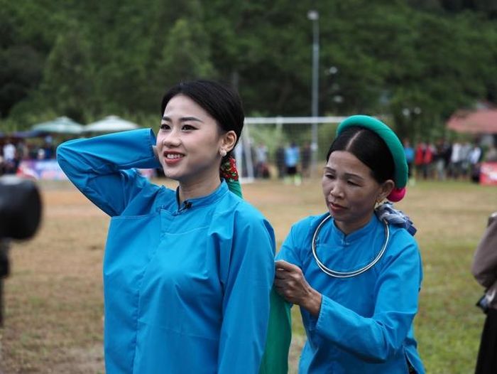 Không chỉ là một giải đấu thể thao, giải bóng đá nữ dân tộc thiểu số ở Bình Liêu còn là sự kiện văn hóa, sản phẩm du lịch giúp quảng bá hình ảnh tỉnh Quảng Ninh. Ảnh một nữ du khách trải nghiệm nghi thức "báo thai": vấn khăn của phụ nữ dân tộc Sán Chỉ ở Húc Động, Bình Liêu