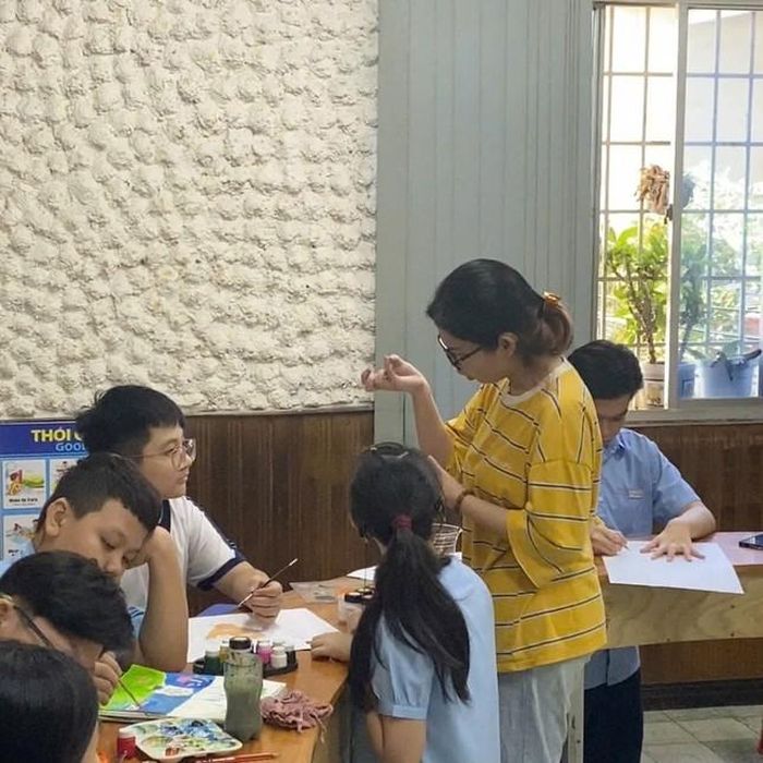 Như Nguyệt (áo vàng) đang đứng lớp dạy vẽ miễn phí cho trẻ.