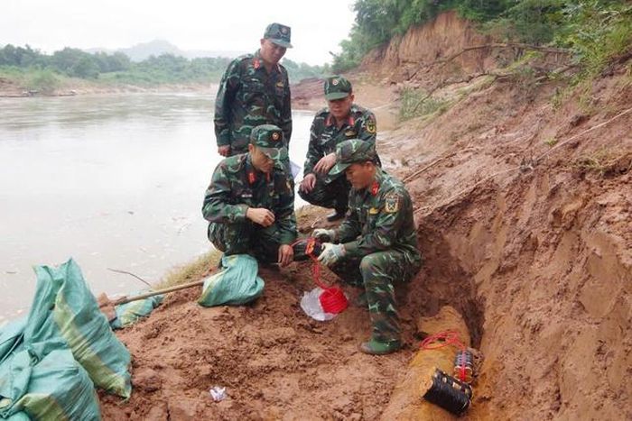 Lực lượng chức năng tiến hành hủy nổ quả bom. Ảnh Hữu Thịnh